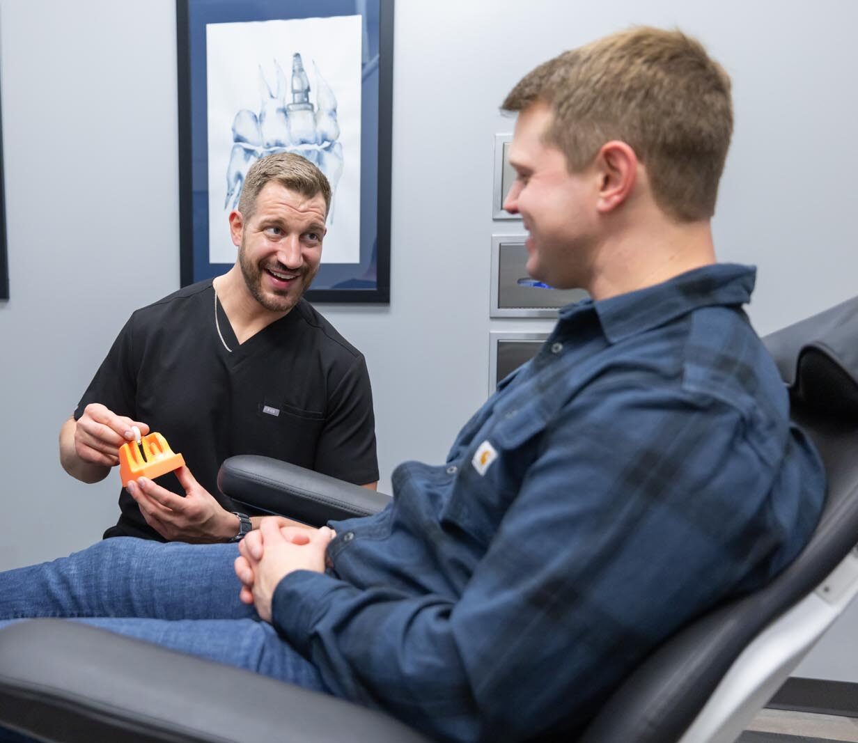 Dr. Chapek showing a patient a model of teeth.